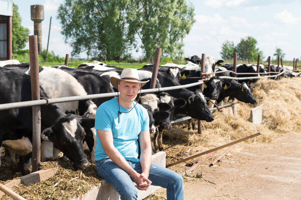 Фермер, работающий на ферме с молочными коровами
