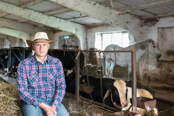 Mezőgazdasági termelő dolgozik a tejelő tehenek a gazdaságban — Stock Fotó