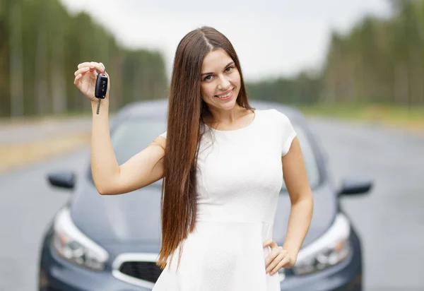 Donna felice conducente che mostra la chiave dell'auto — Foto Stock