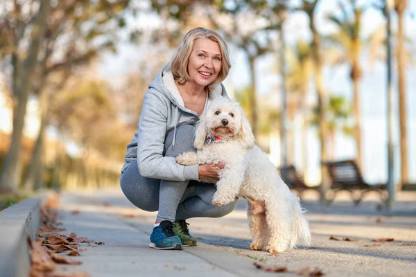 屋外で犬と歩く高齢女性. — ストック写真