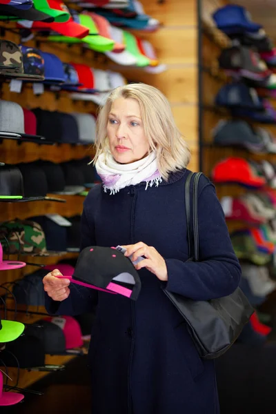 Vrouwen in een hoedenwinkel kiest een hoed. — Stockfoto