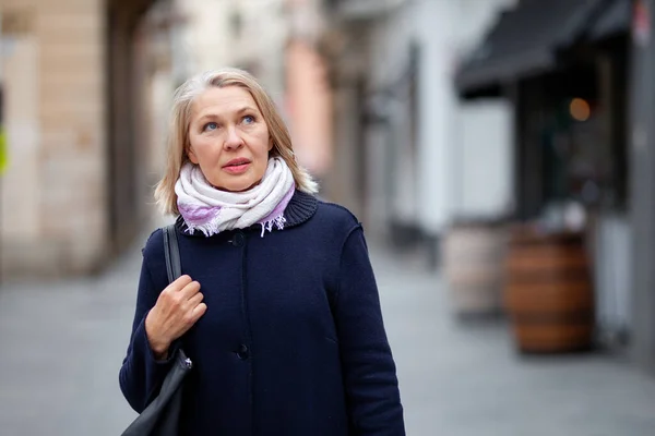 Gelukkig gepensioneerde vrouw loopt de straten van een toeristische stad — Stockfoto