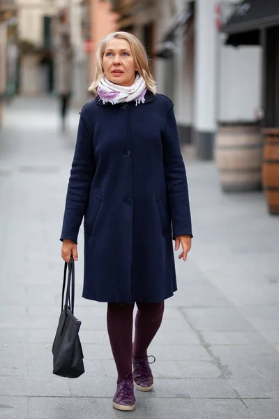 Gelukkig gepensioneerde vrouw loopt de straten van een toeristische stad — Stockfoto