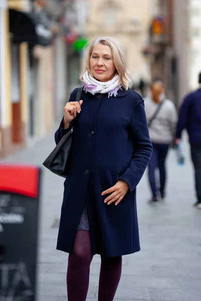 Starší žena turistické procházky ulicemi města — Stock fotografie
