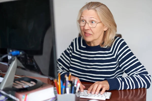 Seriöse ältere Menschen mittleren Alters in Brille mit Laptop-Eingabe E-Mail arbeiten zu Hause im Büro, Dame sucht Informationen im Internet oder online kommunizieren — Stockfoto