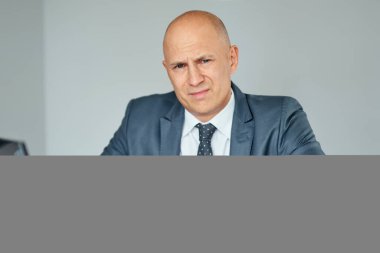 Ofiste dizüstü bilgisayarda çalışan hayal kırıklığına uğramış bir iş adamı..