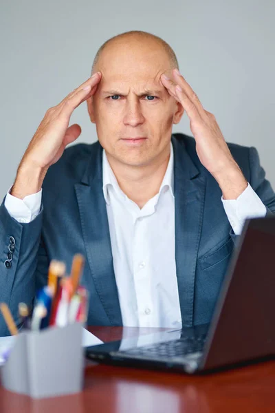 Frustré jeune homme d'affaires travaillant sur ordinateur portable au bureau — Photo