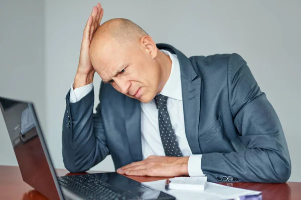 Homem estressado no escritório olhando para documentos . — Fotografia de Stock