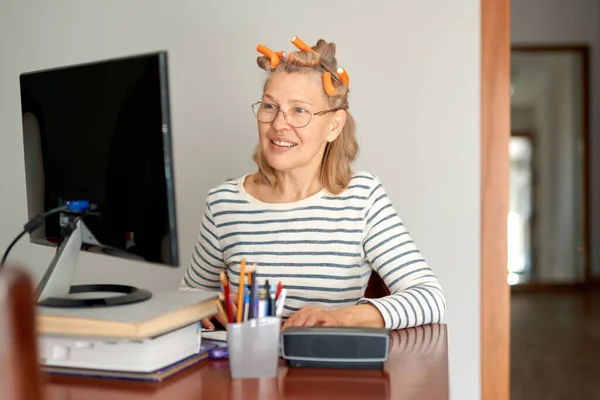 Vrouw Met Krulspelden Haar Hoofd Kijkt Naar Een Computer Scherm — Stockfoto