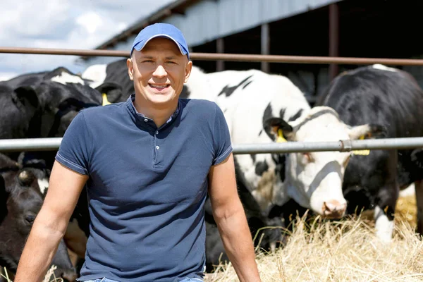 Ritratto di un agricoltore positivo con una mucca in un ranch — Foto Stock