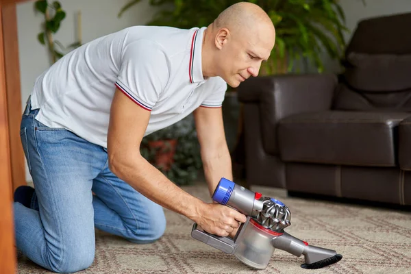 Man met stofzuiger thuis.Thuis klusjes en routine concept. — Stockfoto