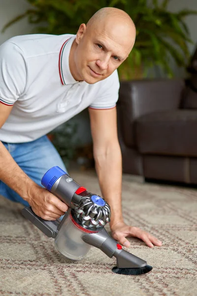 Homem com aspirador de pó em casa.tarefas domésticas e conceito de rotina . — Fotografia de Stock