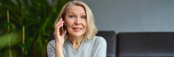 Glad Mogen Kvinna Som Använder Mobiltelefon När Hon Sitter Soffan — Stockfoto