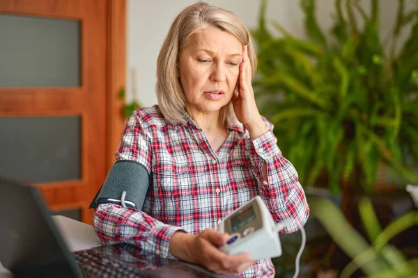 Medición de la presión arterial de la mujer adulta mediante un tonómetro electrónico — Foto de Stock