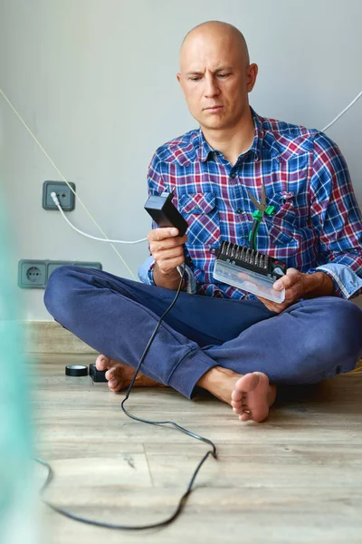 Homem repara um eletricista em casa . — Fotografia de Stock