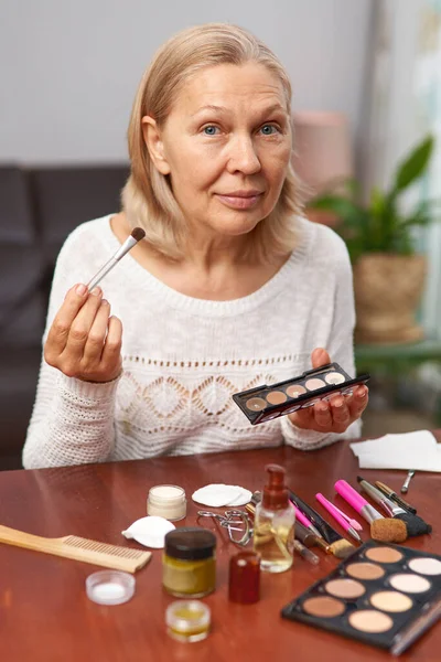 Mulher idosa colocando maquiagem em casa — Fotografia de Stock