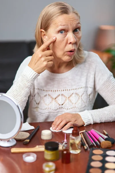 Mulher examina rugas ao redor de seus olhos . — Fotografia de Stock