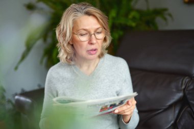 haber, basın, medya, tatiller ve insanların kavramı - kadın evde gazete okuyor.