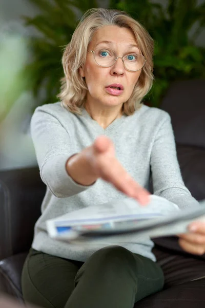 Geschockt, Frau liest Zeitung, schlechte Nachrichten. — Stockfoto