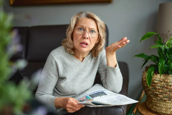 Shocked, woman reading newspaper, bad news . — стоковое фото