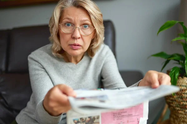 Geschockt, Frau liest Zeitung, schlechte Nachrichten. — Stockfoto