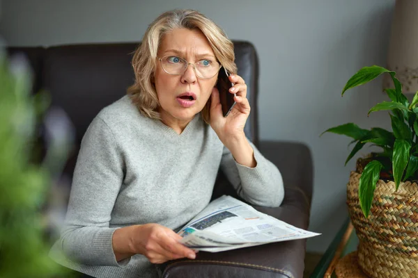 Geschokt, vrouw leest krant, slecht nieuws. — Stockfoto