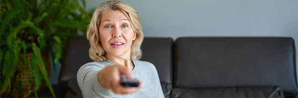 Erwachsene Frau schaut zu Hause fern. — Stockfoto