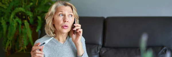 Sickness, seasonal virus problem concept. Senior woman being sick having flu at temperature on thermometer. — Stock Photo, Image