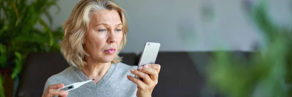 Ziekte, seizoensgebonden virus probleem concept. Oudere vrouw ziek met griep op temperatuur op thermometer. — Stockfoto