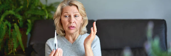 Ziekte, seizoensgebonden virus probleem concept. Oudere vrouw ziek met griep op temperatuur op thermometer. — Stockfoto