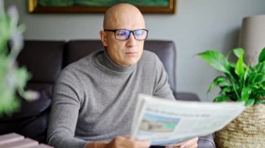 haber, basın, medya, tatiller ve insanların kavramı - adam evde gazete okuyor.