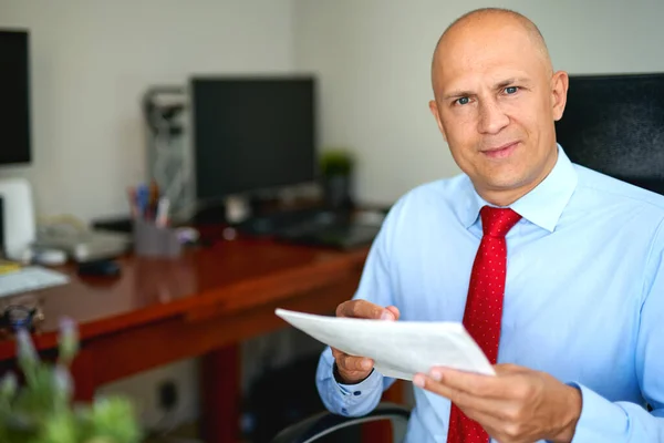 Ofiste mavi gömlekli ve kırmızı kravatlı bir adam var. — Stok fotoğraf