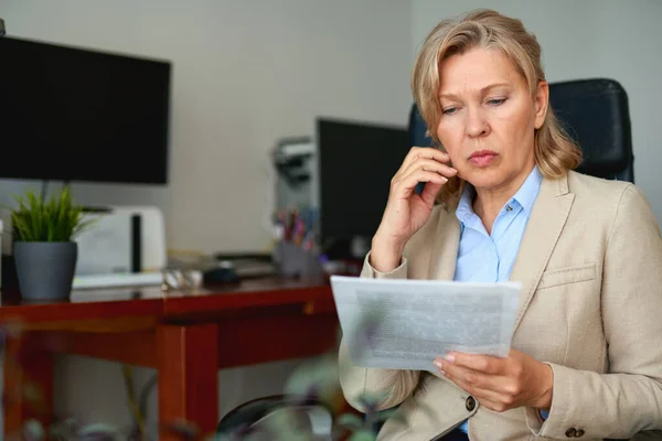 Senior zakenvrouw werkt met documenten op kantoor interieur. — Stockfoto