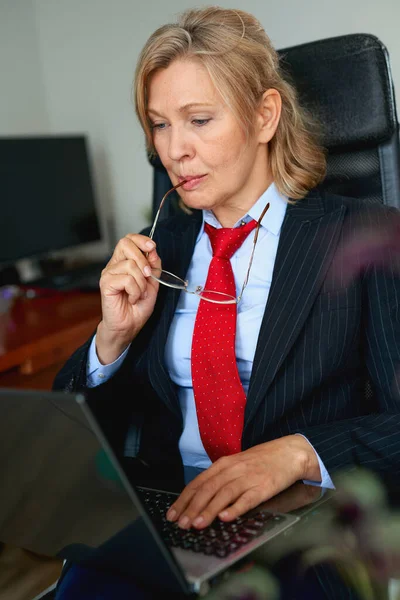 Portrait of mature female boss working in office sitting in a chair — Stock Photo, Image