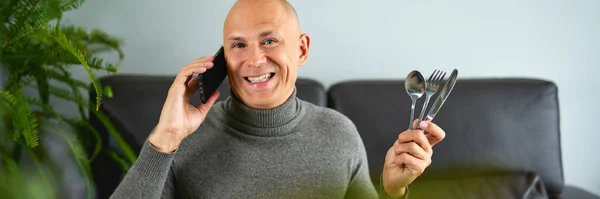 Hombre hablando en el teléfono móvil en el sofá —  Fotos de Stock