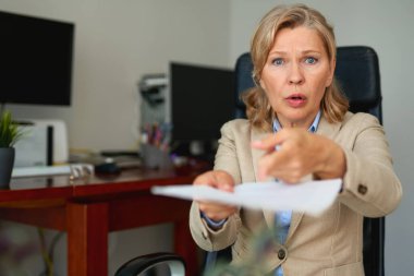 Ofis içi belgelerle çalışan kıdemli iş kadını..