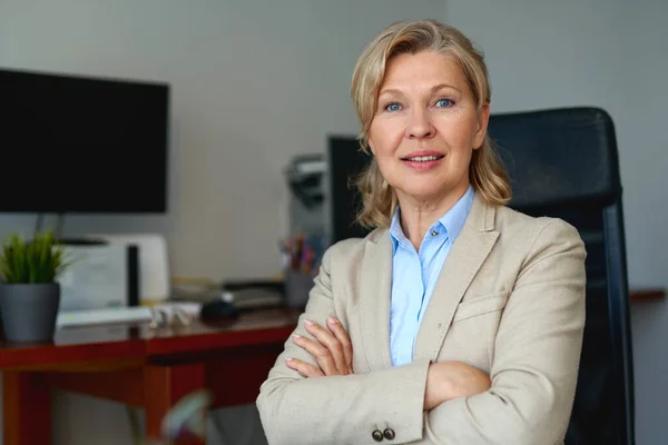 Portrait of mature female boss working in office sitting in a chair — Stock Photo, Image