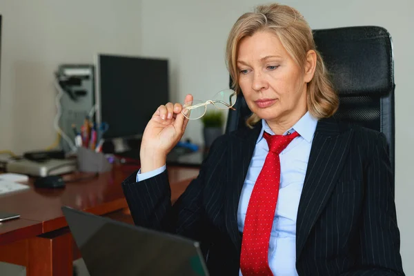 Portrait of mature female boss working in office sitting in a chair — Stock Photo, Image