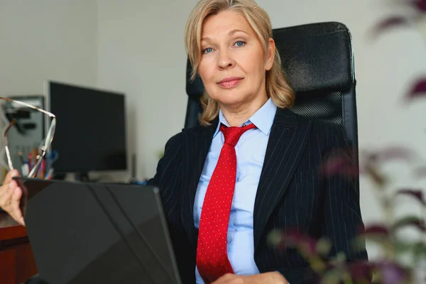 Портрет зрілої жінки в костюмі і червона краватка в офісі — стокове фото