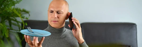 Muž mluví na mobilním telefonu na pohovce — Stock fotografie