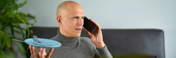 Man pratar på mobiltelefon på soffan — Stockfoto