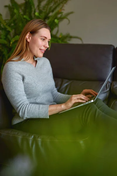 Mulher bonita usando um computador portátil em casa — Fotografia de Stock