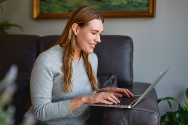 Genç ve güzel bir kadın dizüstü bilgisayar kullanıyor.