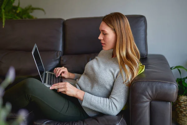 Mulher bonita usando um computador portátil em casa — Fotografia de Stock