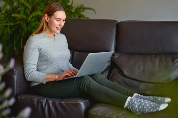Mulher bonita usando um computador portátil em casa — Fotografia de Stock
