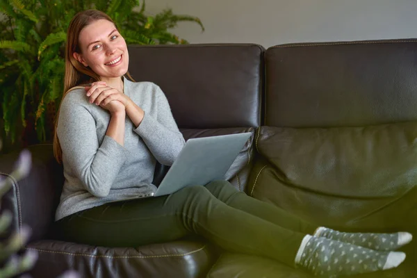 Beautiful woman using a laptop computer at home — Stock Photo, Image