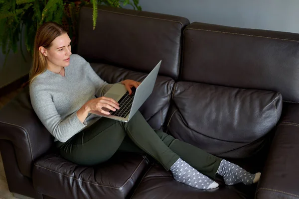 Beautiful woman using a laptop computer at home — Stock Photo, Image