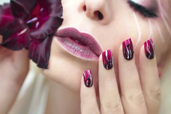 Burgundy manicure with gladiolus. — Stock Photo, Image