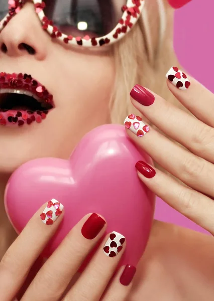 Holiday makeup and manicure with red hearts. — Stock Photo, Image