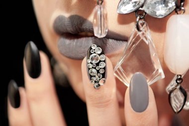 Mat siyah gri glam makyaj ve manikür rhinestones ve kızın yüzü closeup dekorasyon ile.